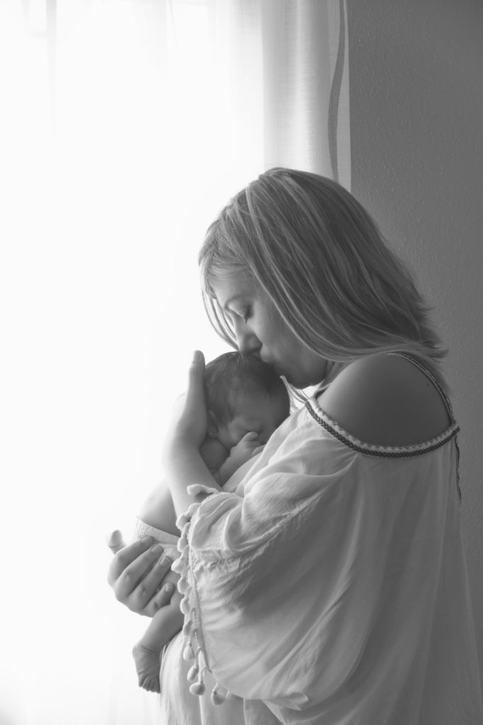 fotografía de madre abrazando y besando a un bebé