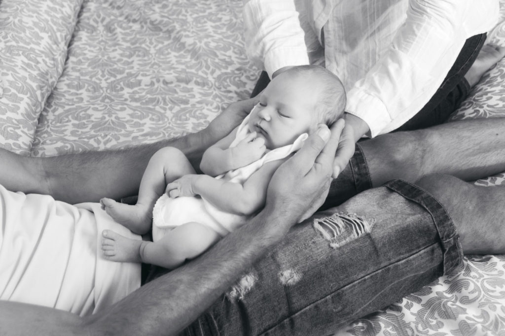 fotografía de papás cogiendo a un bebé